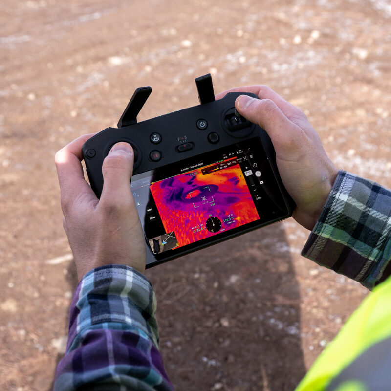 Technik FLO ovládá termovizní dron nad plochou střechou